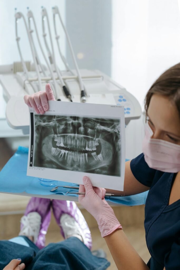 Dentist showing dental x-ray during consultation in a modern clinic setting.