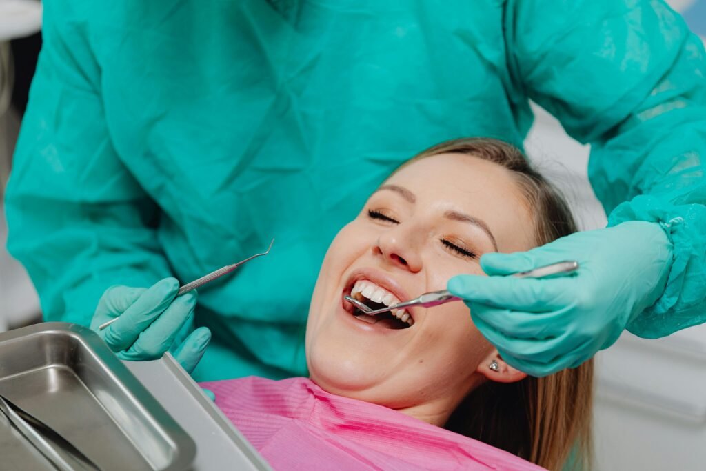 A happy woman receiving a dental examination, showing confidence in professional oral care.