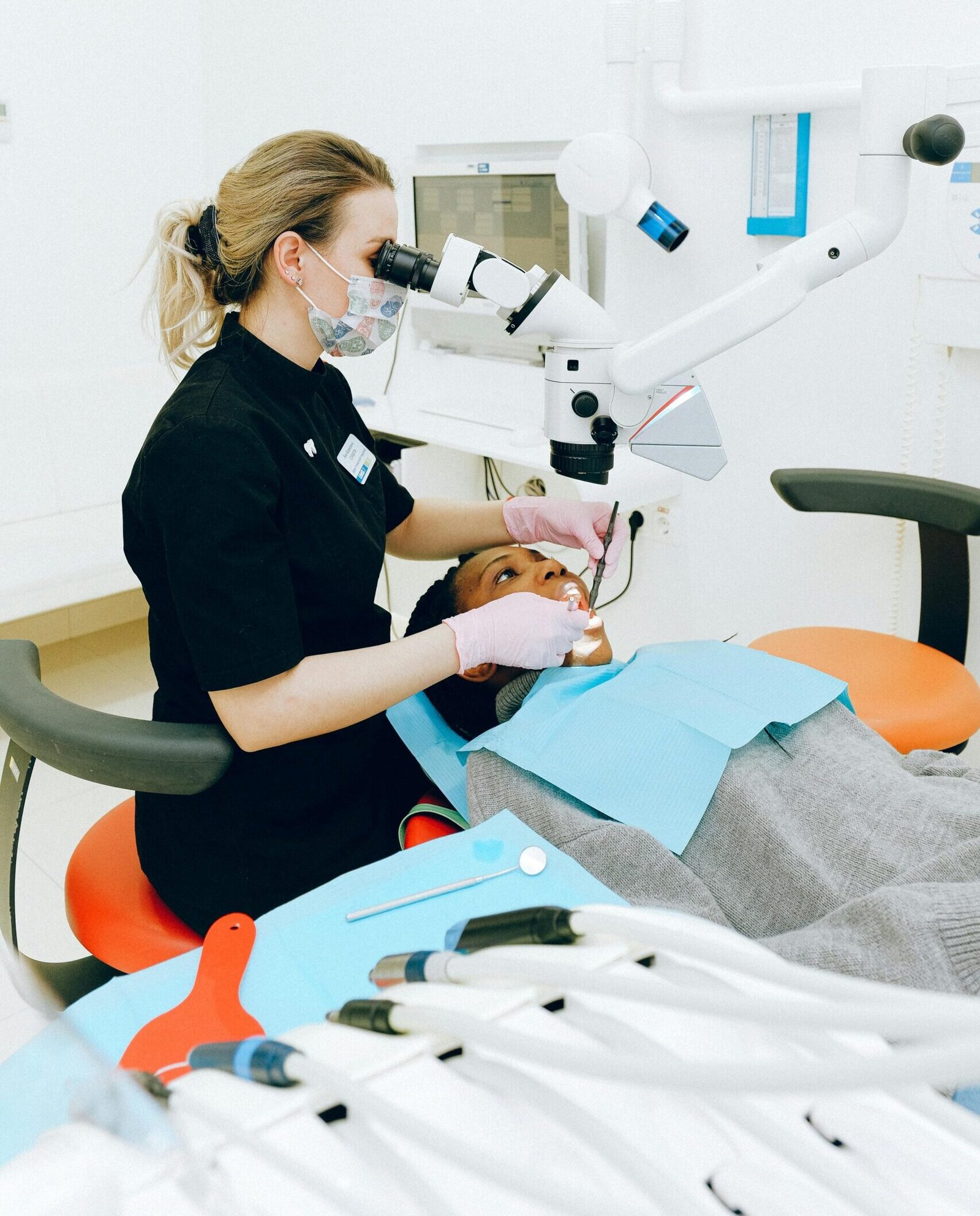 Female dentist in clinic examining a patient with modern dental equipment.