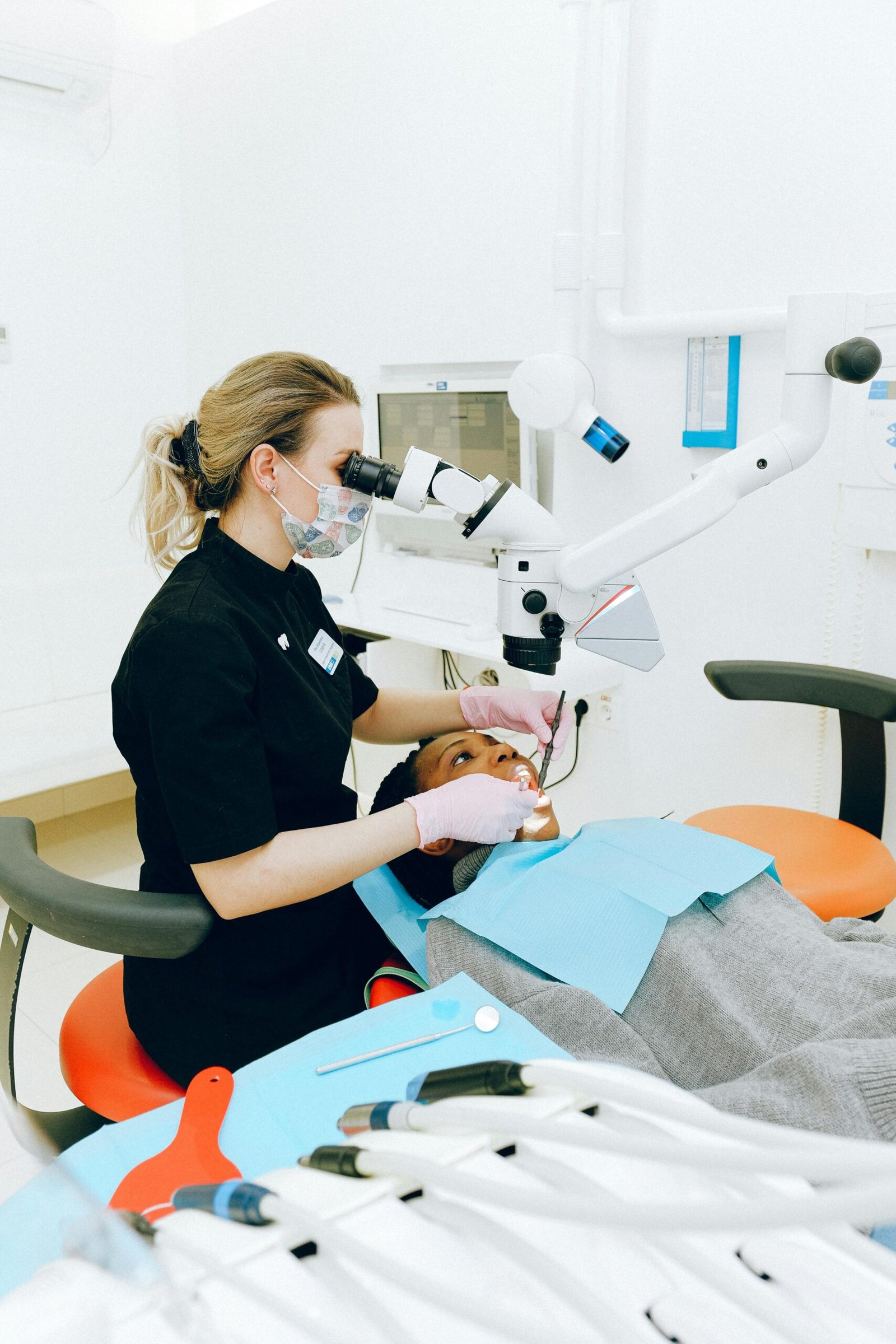 Female dentist in clinic examining a patient with modern dental equipment.